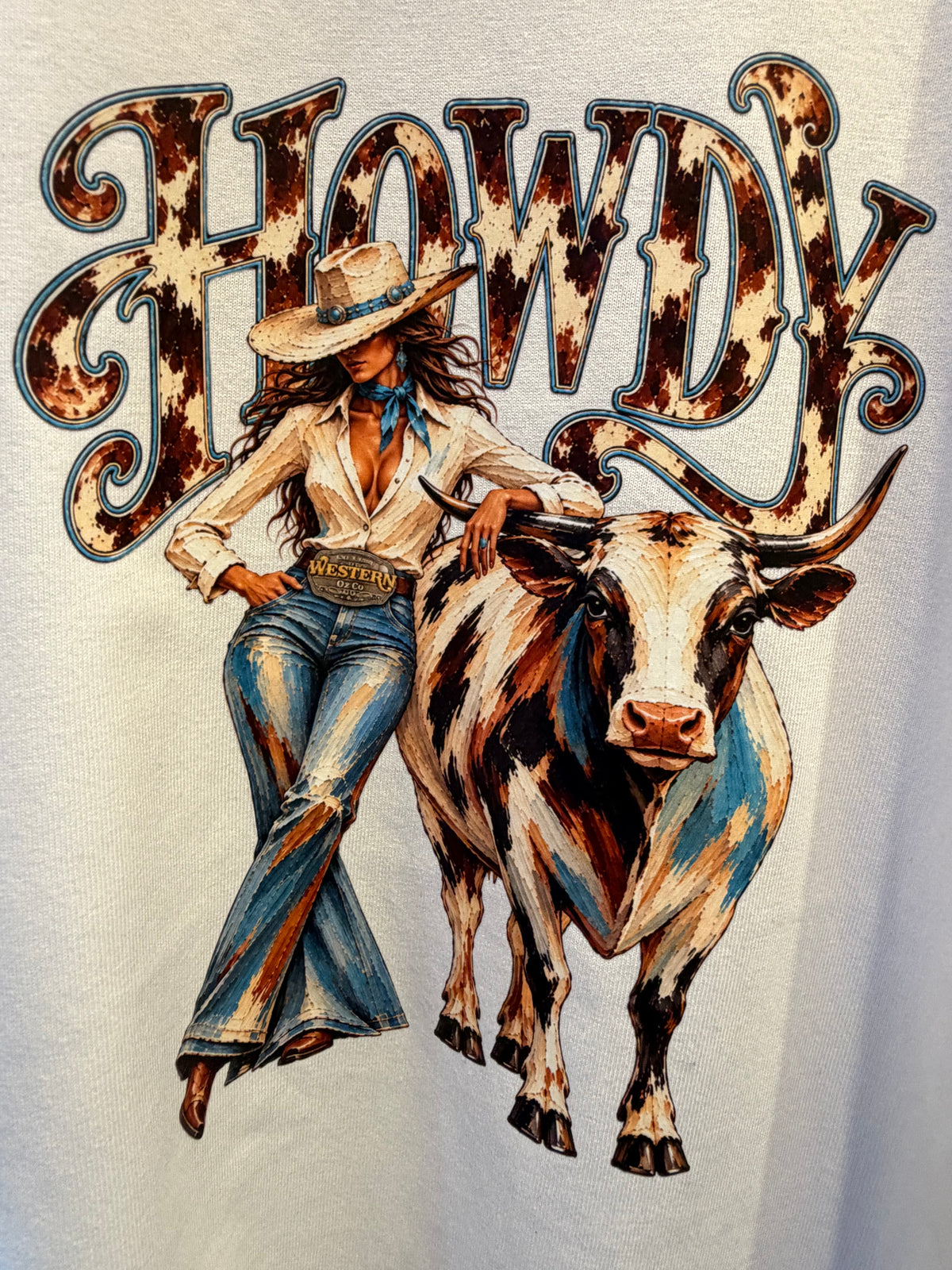 Close-up of the HOWDY cowgirl and longhorn graphic on the white tee