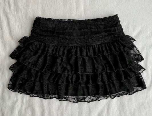 Front view of black tiered floral lace mini skort